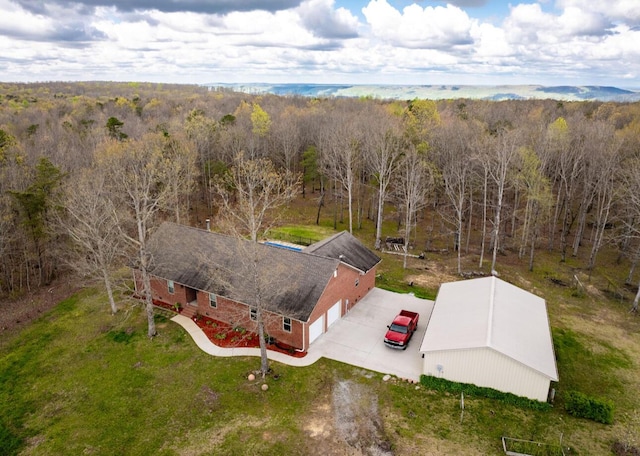 drone / aerial view featuring a wooded view