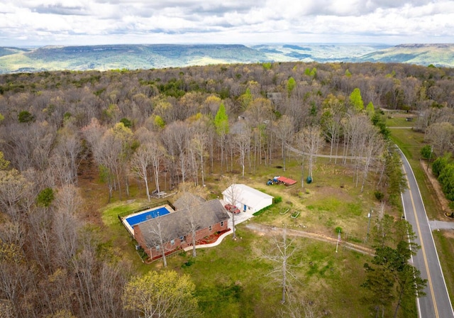 drone / aerial view featuring a wooded view
