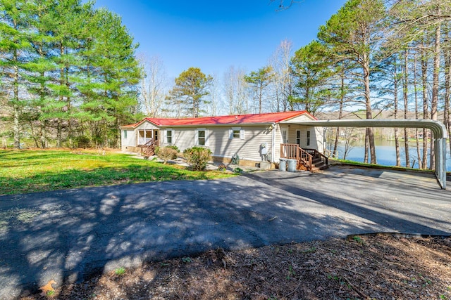 view of front of house featuring a front lawn, metal roof, and aphalt driveway