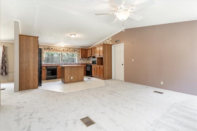 255 Bible Gulf Rd, Menlo, GA 30731 - kitchen with brown cabinetry, vaulted ceiling, black appliances, a kitchen island, and light carpet