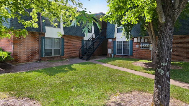 900 Mountain Creek Rd # R311, Chattanooga, TN 37405 - view of front of home featuring brick siding, a front lawn, roof with shingles, and stairs