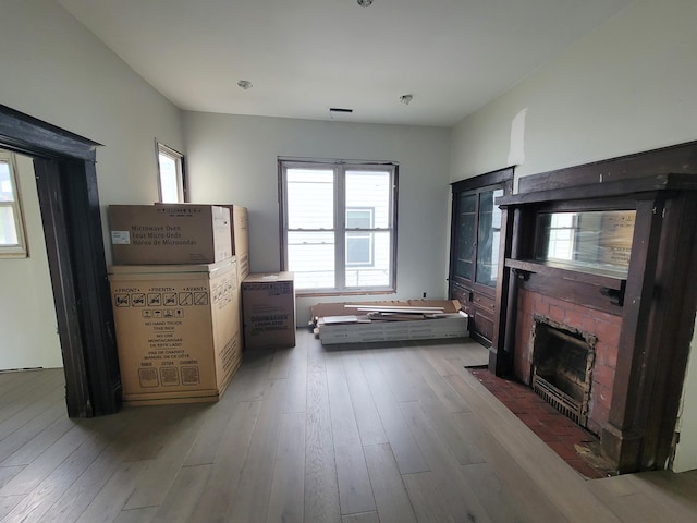 living area with plenty of natural light, wood-type flooring, and a fireplace