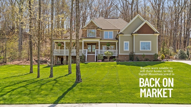 craftsman house featuring covered porch, a front yard, and brick siding