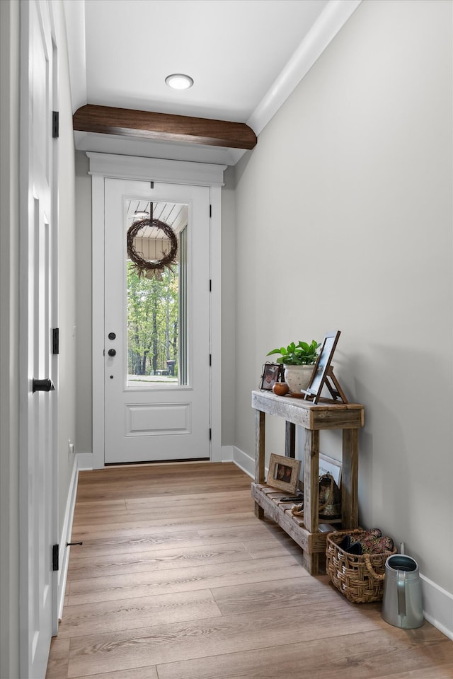 entryway with light wood-type flooring, baseboards, and beamed ceiling