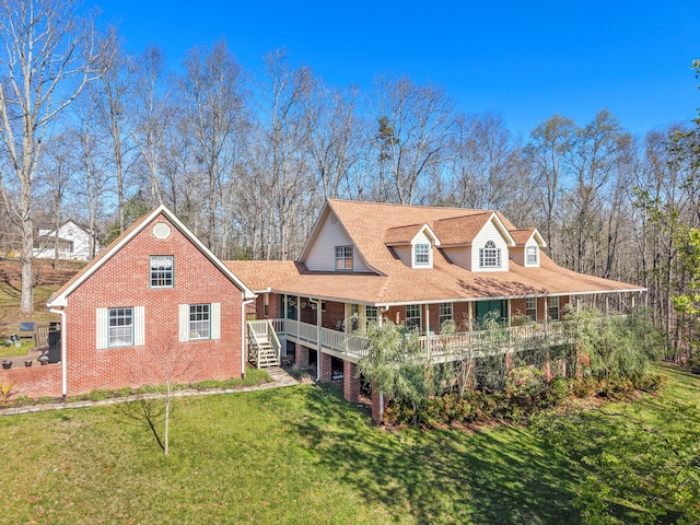 view of front facade featuring brick siding, a front lawn, and covered porch