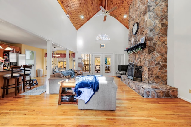 living room with ceiling fan, a fireplace, high vaulted ceiling, wood ceiling, and wood finished floors
