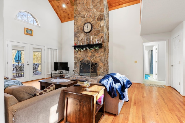 living area featuring wooden ceiling, a stone fireplace, wood finished floors, french doors, and high vaulted ceiling