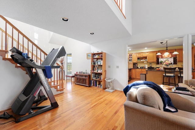 living room featuring recessed lighting, stairs, light wood-style flooring, and baseboards