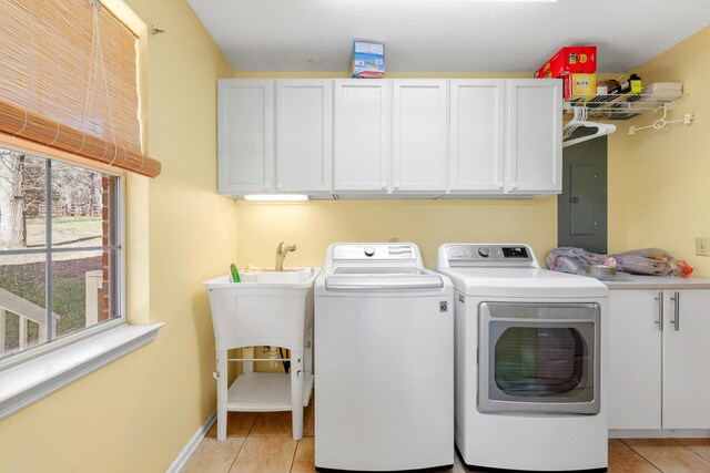 clothes washing area with cabinet space, separate washer and dryer, electric panel, and light tile patterned flooring