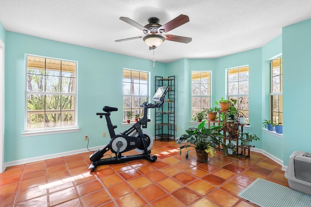 exercise room with a wealth of natural light, a textured ceiling, and ceiling fan