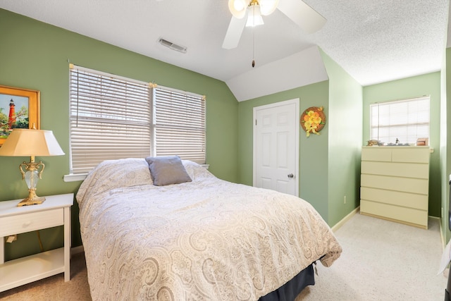 bedroom featuring visible vents, a ceiling fan, a textured ceiling, vaulted ceiling, and light colored carpet