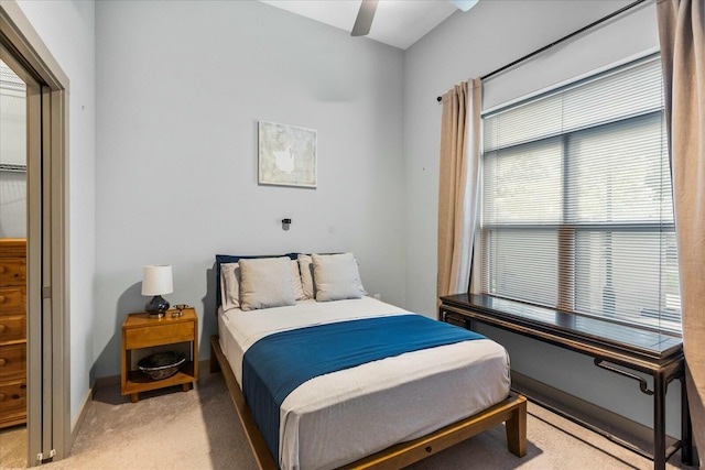 bedroom with light carpet, baseboards, and a ceiling fan