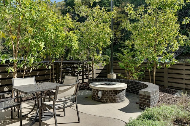 view of patio / terrace featuring outdoor dining space, fence, and an outdoor fire pit