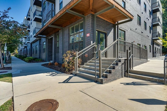 view of exterior entry featuring brick siding