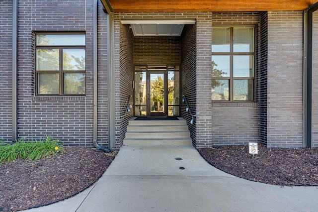 doorway to property featuring brick siding