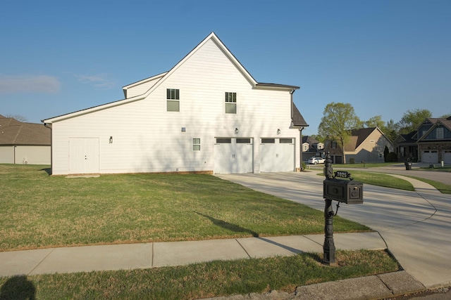 view of side of property featuring a yard, driveway, and a garage