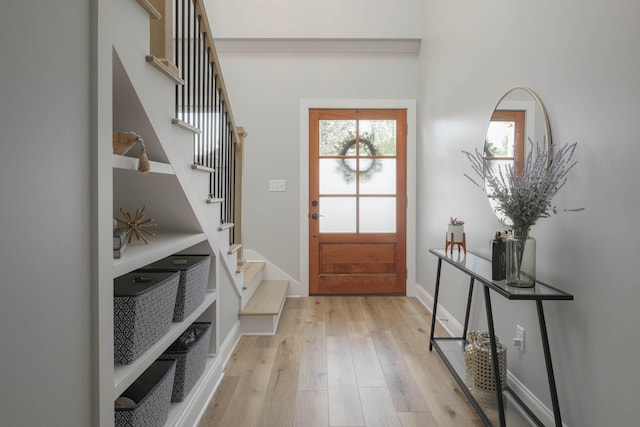 entryway featuring light wood-type flooring, baseboards, and stairway