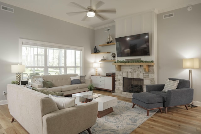 living area featuring light wood finished floors, a ceiling fan, and visible vents