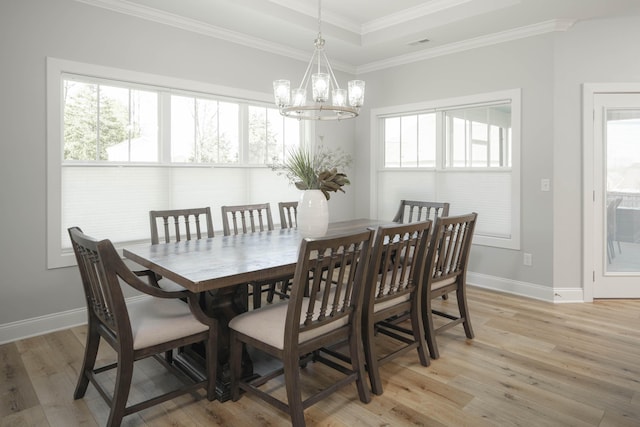 dining room featuring a chandelier, light wood-style floors, ornamental molding, and a healthy amount of sunlight