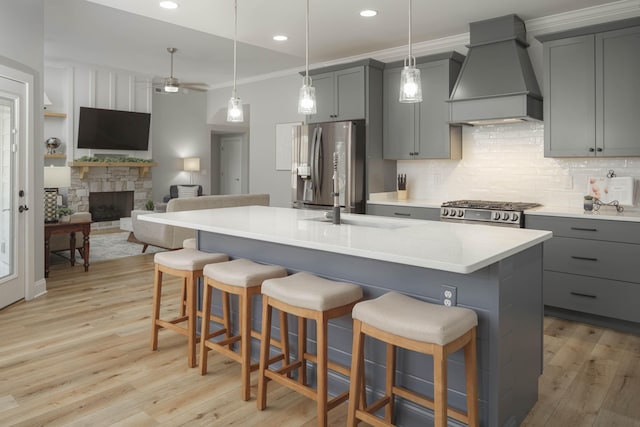 kitchen featuring stainless steel appliances, custom exhaust hood, light wood-style floors, and gray cabinetry