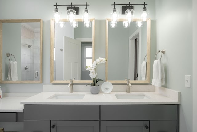 bathroom with a shower stall, double vanity, and a sink