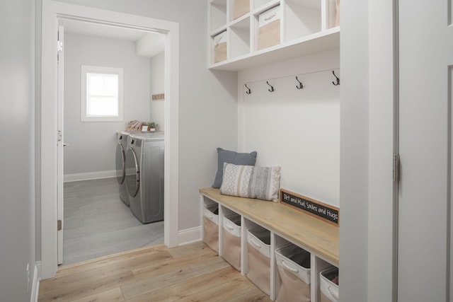 mudroom featuring light wood-type flooring, baseboards, and washing machine and dryer