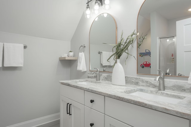 full bath with double vanity, a sink, and vaulted ceiling