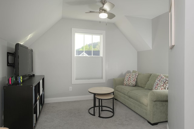 carpeted living area with baseboards, a ceiling fan, and vaulted ceiling