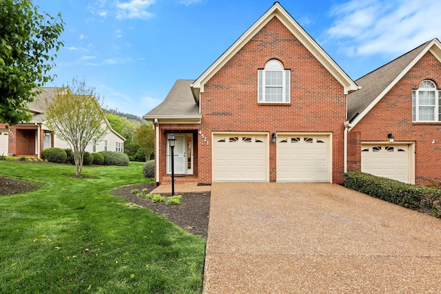traditional-style house featuring brick siding, driveway, a garage, and a front lawn