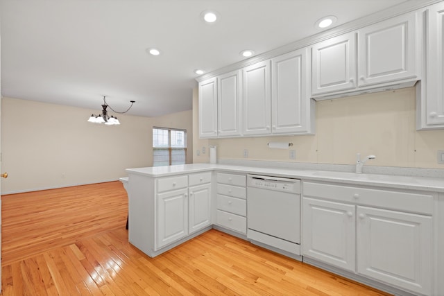 kitchen featuring dishwasher, light countertops, a chandelier, a peninsula, and white cabinetry