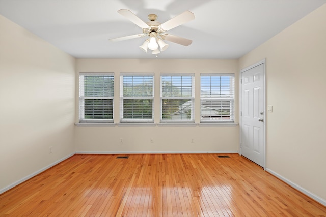 spare room with visible vents, a wealth of natural light, light wood-style floors, and baseboards