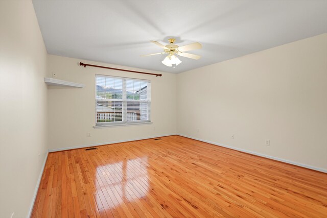 empty room with light wood-style flooring, ceiling fan, baseboards, and visible vents