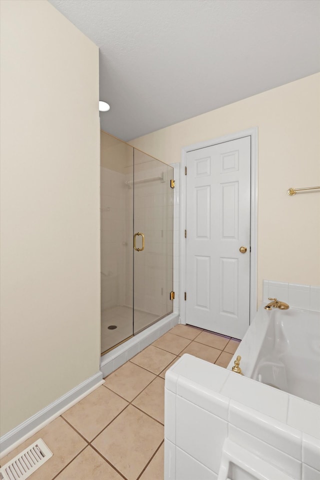 full bath with a garden tub, a shower stall, visible vents, tile patterned floors, and baseboards