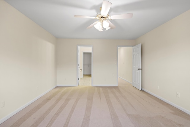 unfurnished bedroom with light colored carpet, baseboards, and a ceiling fan