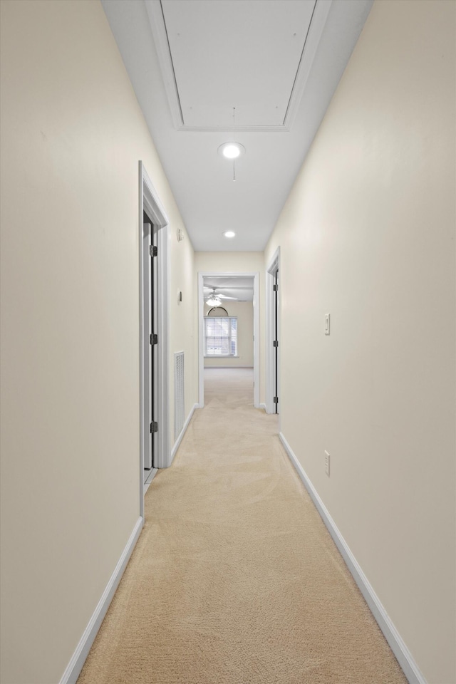 corridor featuring light colored carpet, attic access, baseboards, and recessed lighting