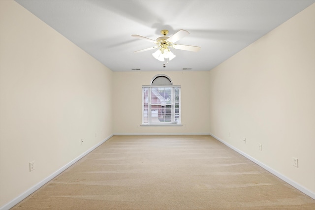 unfurnished room with light colored carpet, visible vents, baseboards, and a ceiling fan