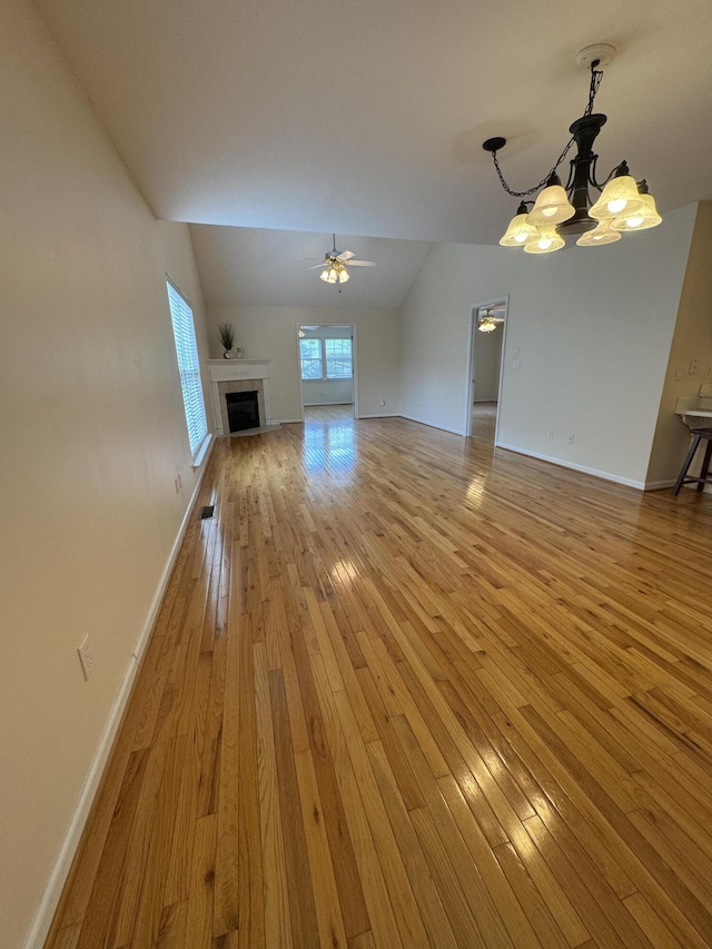 4521 Solomon Seal Trl, Chattanooga, TN 37415 - unfurnished living room with a chandelier, vaulted ceiling, light wood-type flooring, a tiled fireplace, and ceiling fan
