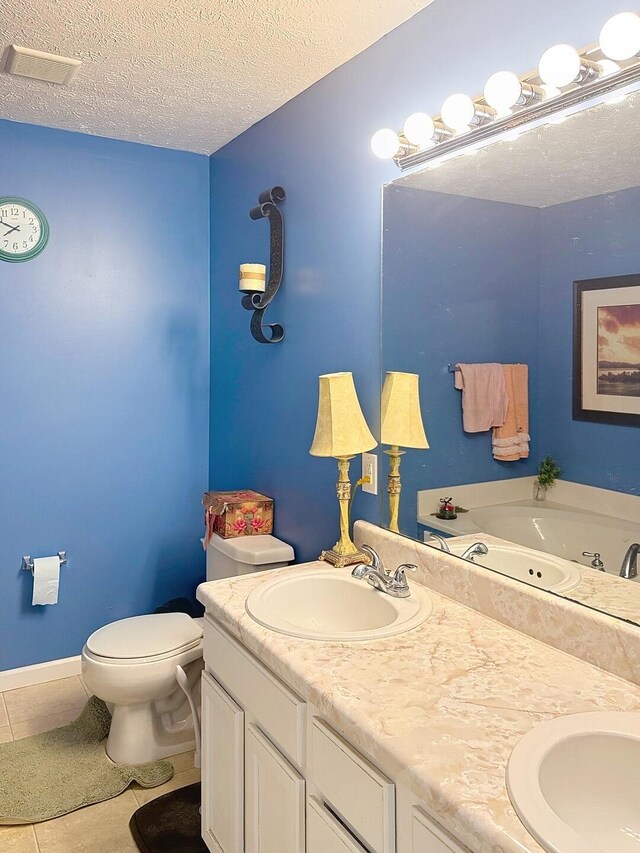 bathroom with a sink, tile patterned floors, double vanity, and a textured ceiling