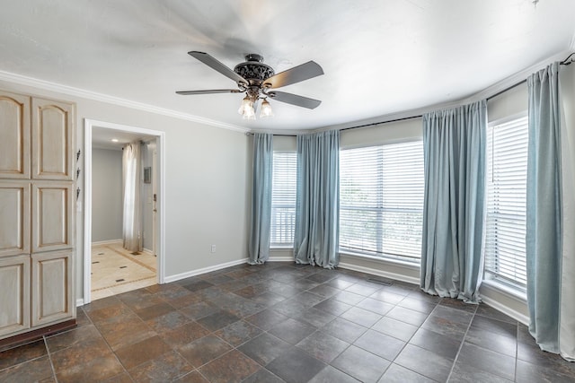 unfurnished room with baseboards, a ceiling fan, and crown molding