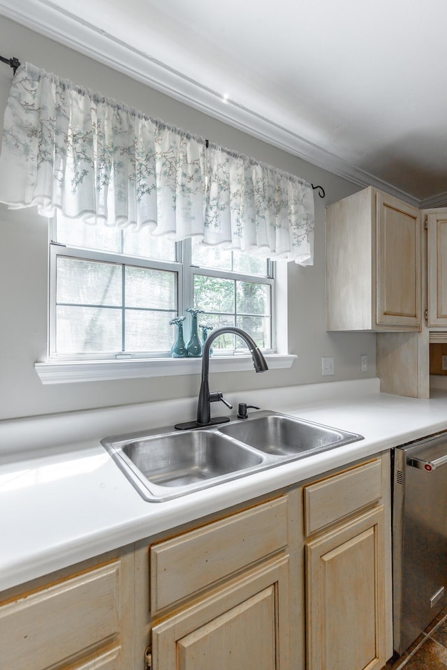 kitchen featuring light countertops, a sink, stainless steel dishwasher, and light brown cabinetry