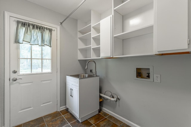 washroom featuring washer hookup, a sink, cabinet space, and baseboards