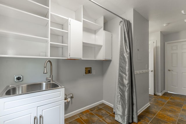 laundry room featuring baseboards, a sink, stone tile flooring, hookup for an electric dryer, and hookup for a washing machine