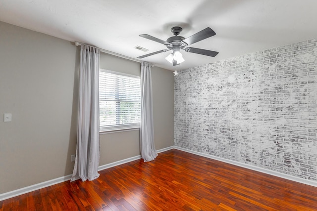 empty room featuring visible vents, ceiling fan, wood finished floors, and baseboards