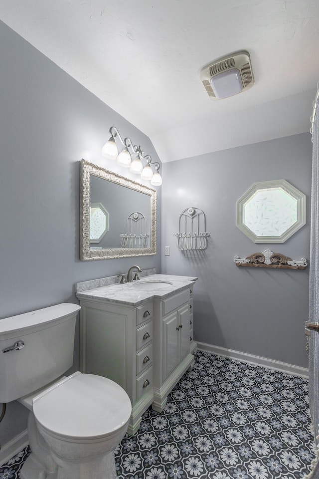 bathroom with vanity, baseboards, vaulted ceiling, and visible vents