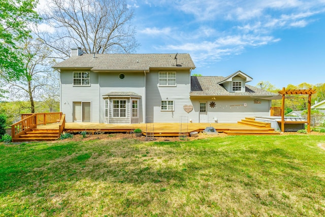 rear view of property featuring roof with shingles, a wooden deck, a lawn, and a chimney