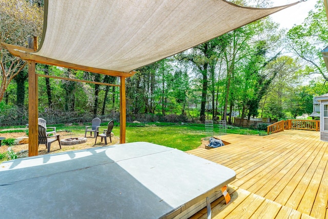wooden deck featuring a lawn and an outdoor fire pit