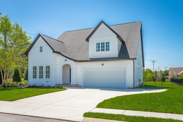 view of front facade featuring board and batten siding, driveway, a front lawn, and fence