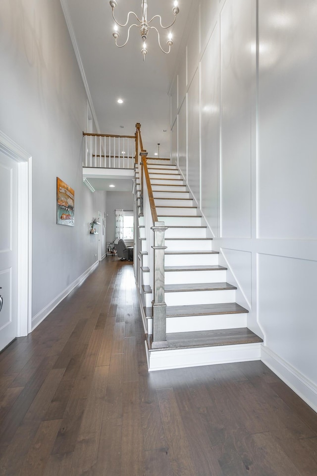stairway featuring recessed lighting, wood finished floors, ornamental molding, baseboards, and a chandelier