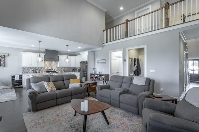 living area featuring wine cooler, dark wood-style floors, baseboards, recessed lighting, and crown molding