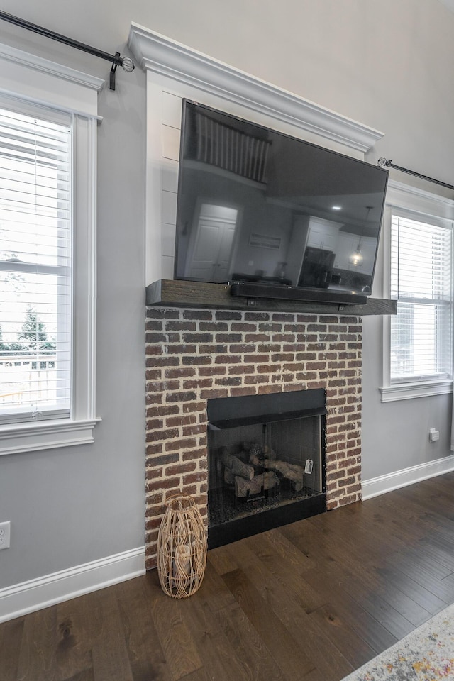 room details with baseboards, wood finished floors, and a brick fireplace